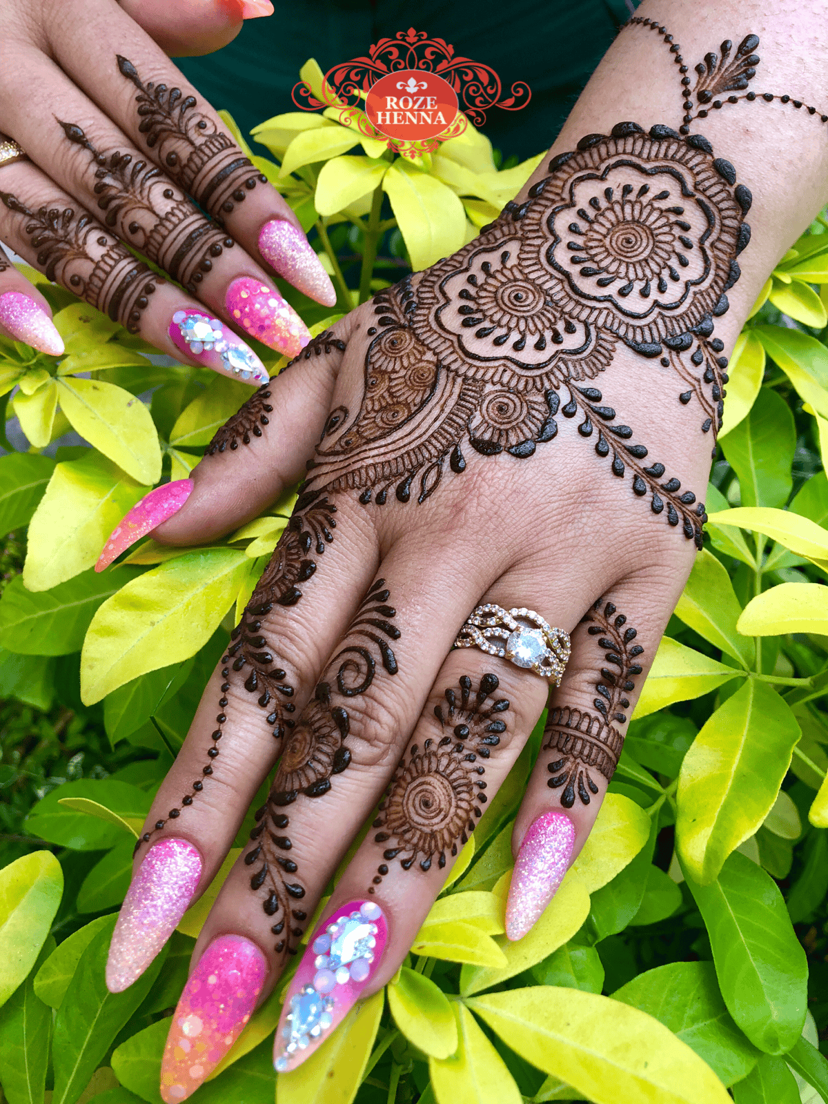 Fresh natural henna applied onto hands ith false nails